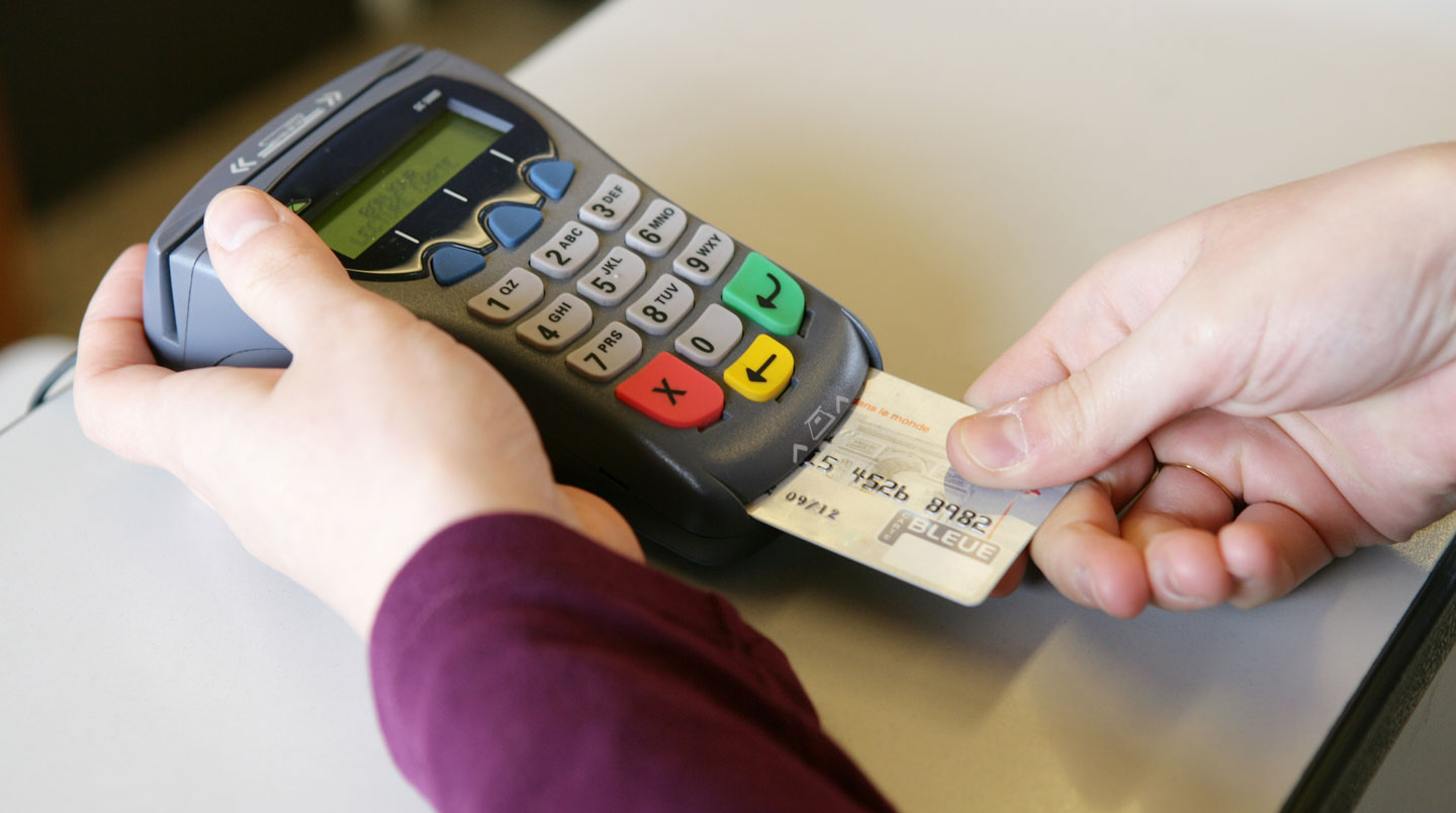 Transaction professionnelle avec carte bancaire professionnelle et terminal de paiement électronique moderne dans un commerce français